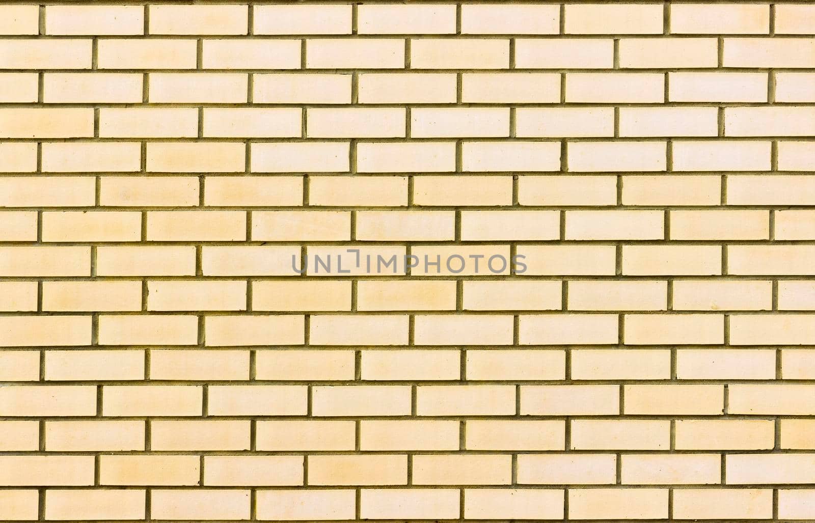 Photograph of a brick wall pattern. The bricks are light yellow in colour.