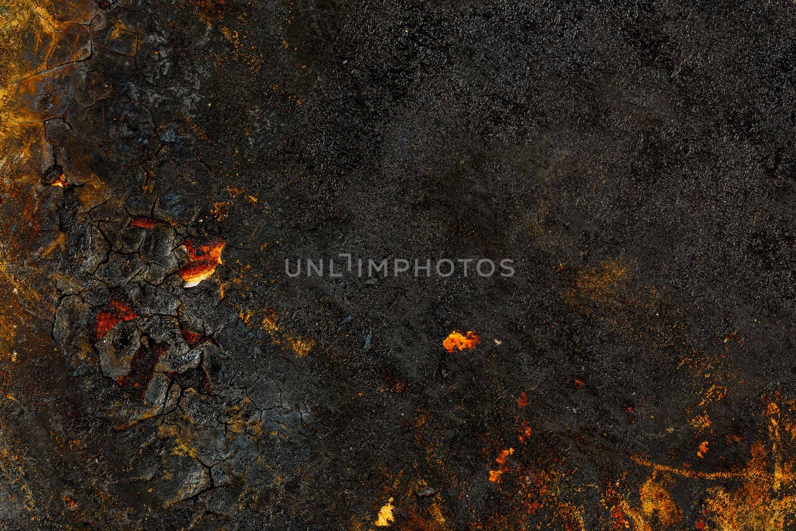 Bottom side of a cast iron pan with thicl layer of soot on its surface. Texture and background.