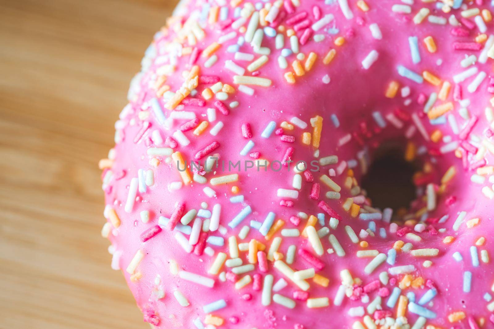 Close up of sugar sprinkled pink donut glace