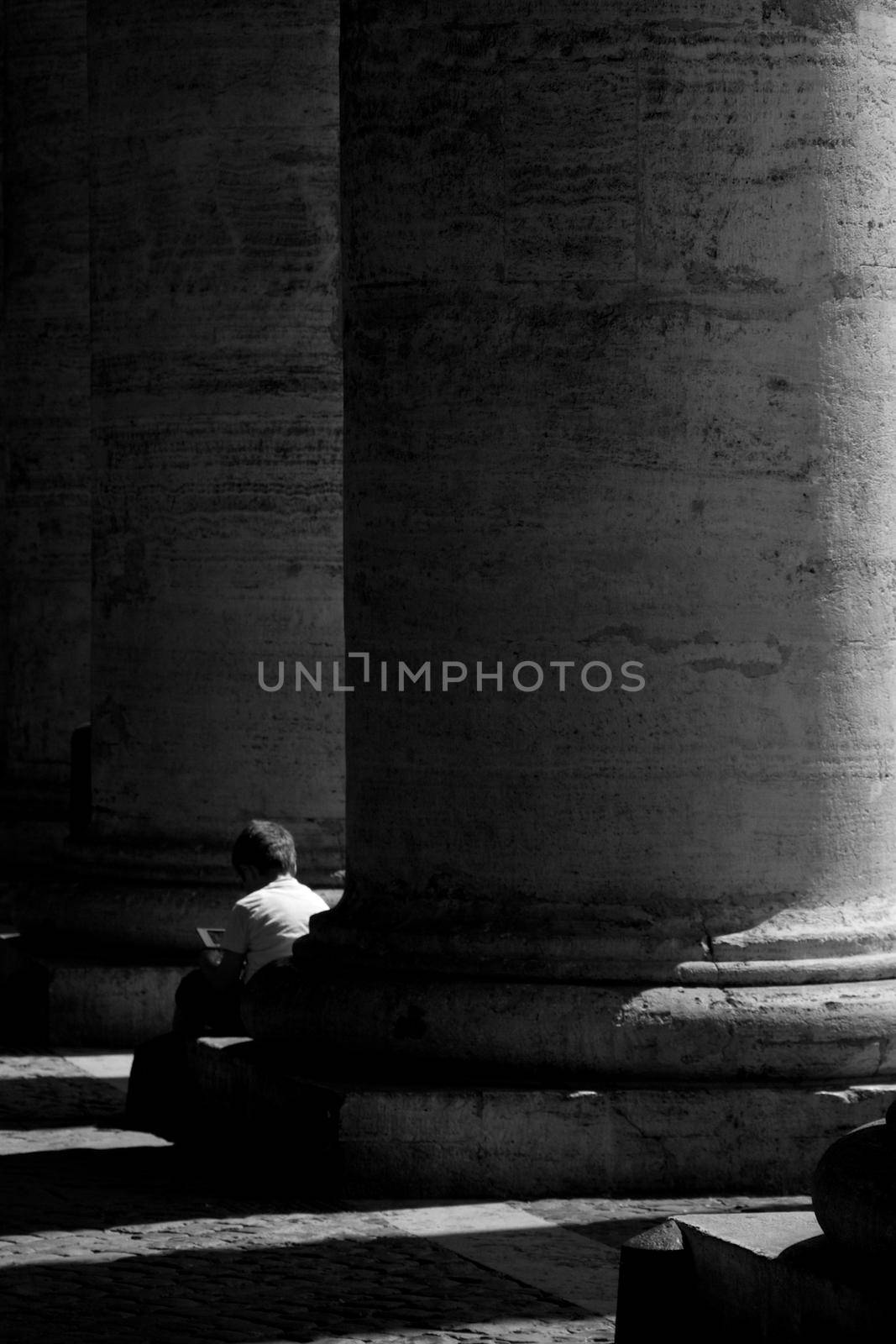 Boy sitting in a stone column