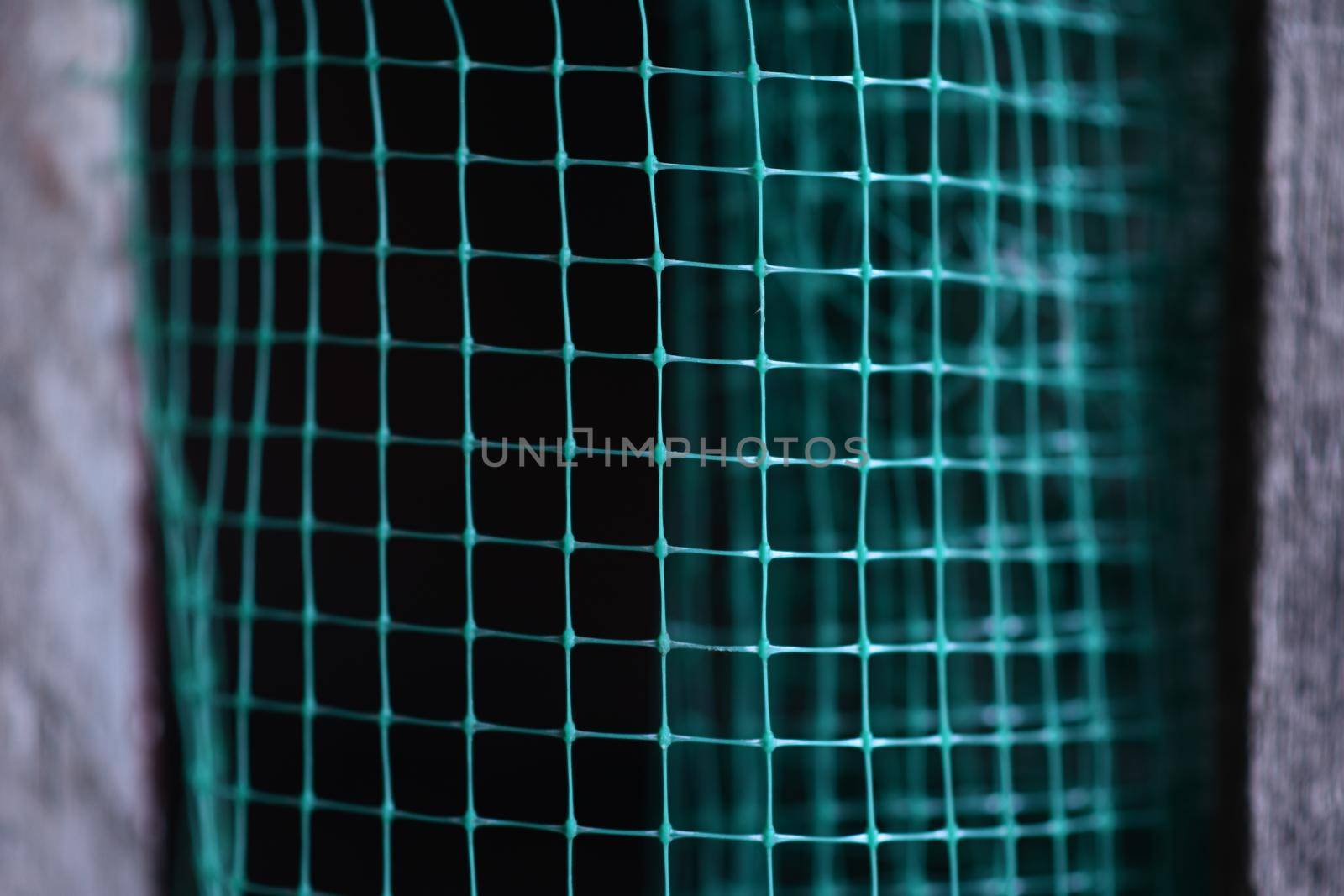 geometrically distorted texture grid. green grid background. Selective focus. High quality photo