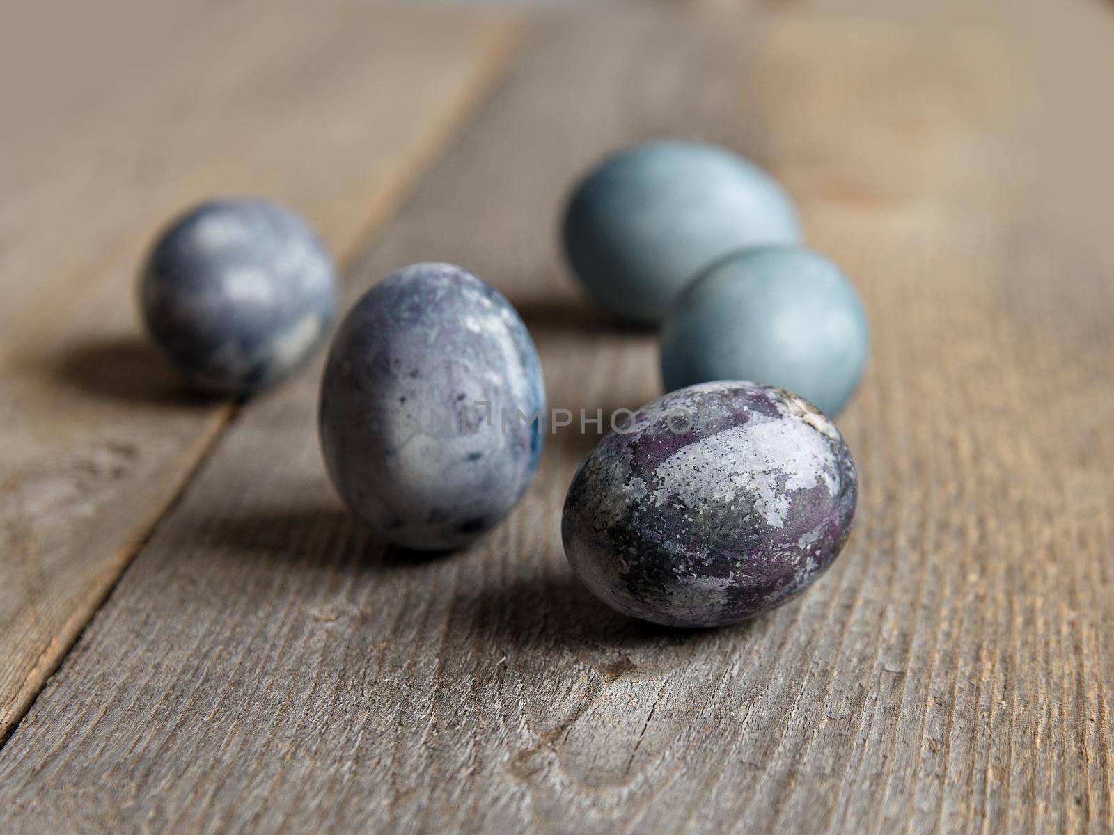 Painted chicken eggs on surface of wooden planks. Selective focus