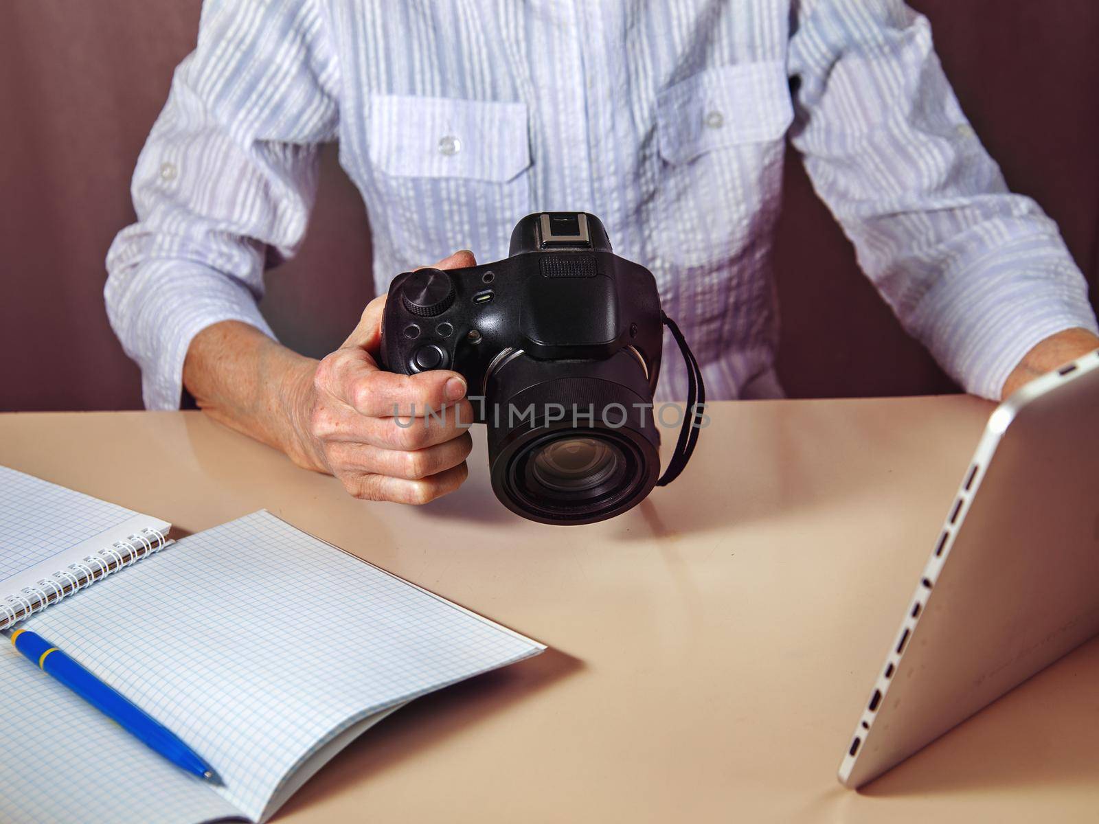 Online training. Tablet, camera, notepad, pen on white table.