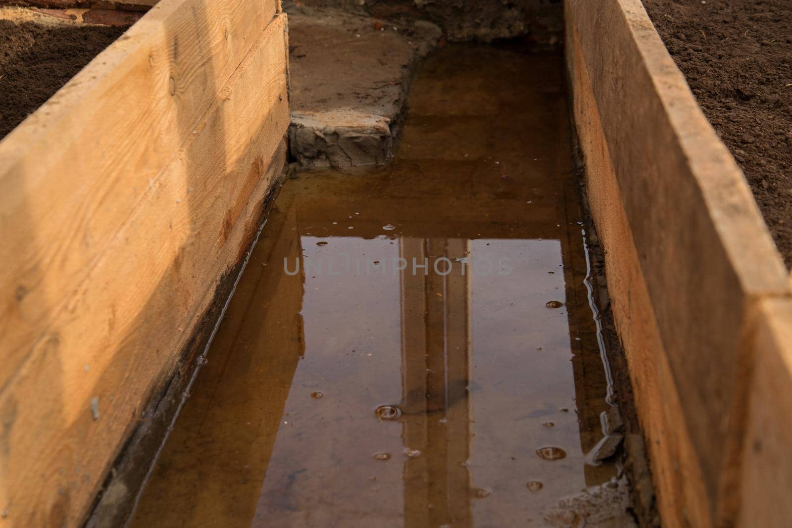 Melt water flooded path between beds in greenhouse.