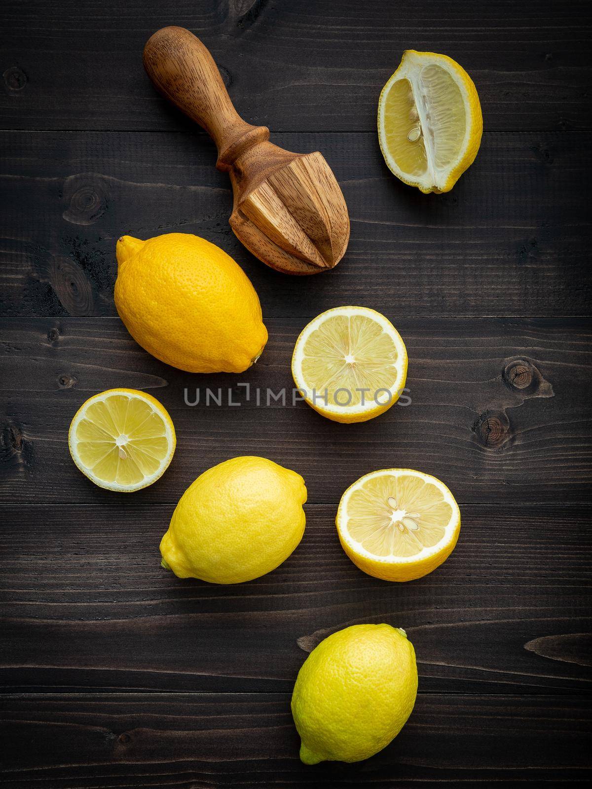 Fresh lemons and  lemons leaves on shabby wooden background. by kerdkanno