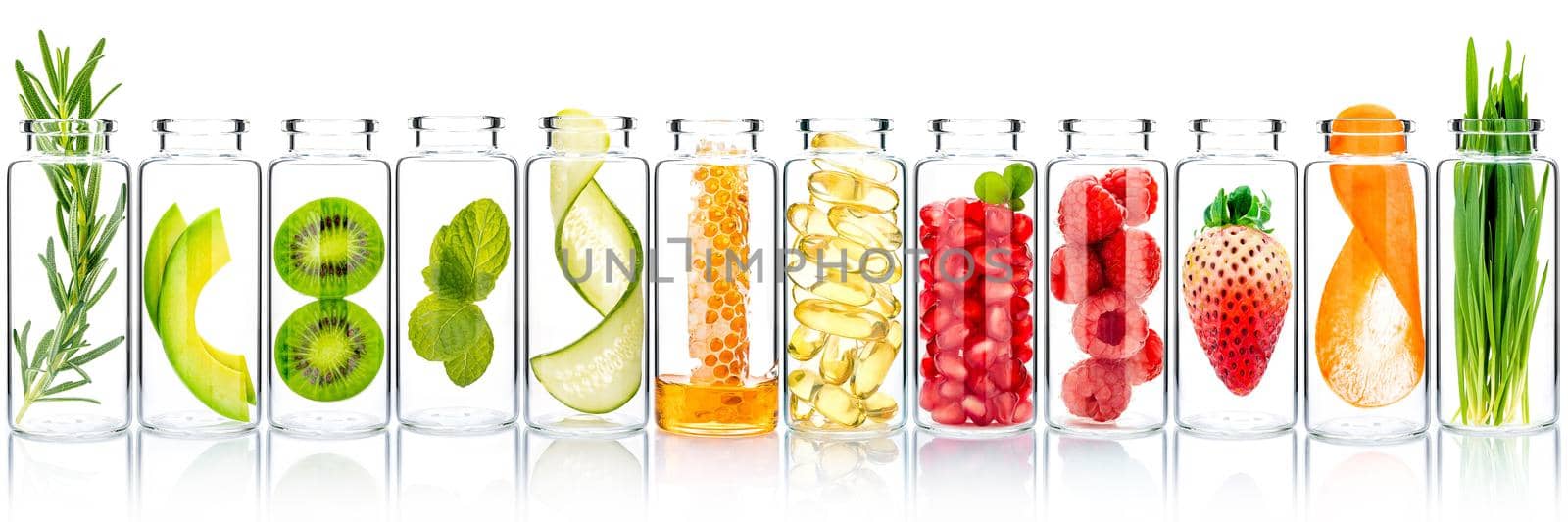 Homemade skin care with fruits ingredients avocado ,orange ,blueberry ,pomegranate ,kiwi ,lemon slice ,cucumber ,tamarind ,strawberry and raspberry in glass bottles isolated on white background.