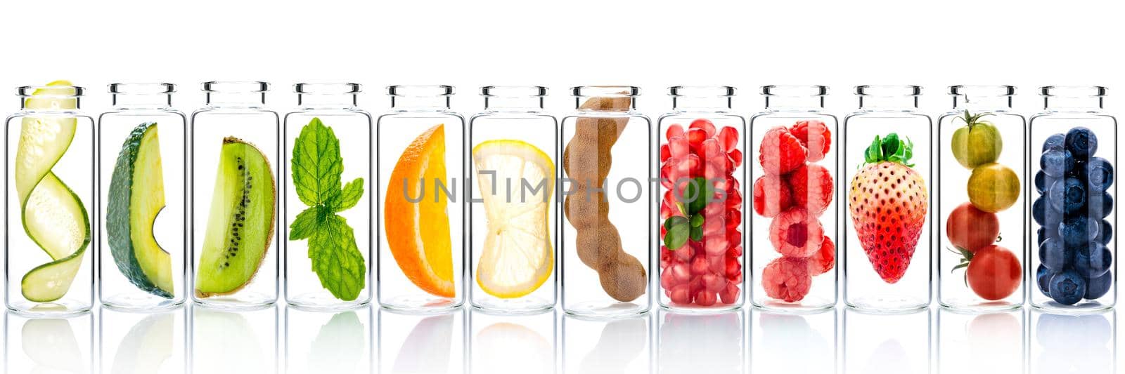 Homemade skin care with fruits ingredients avocado ,orange ,blueberry ,pomegranate ,kiwi ,lemon slice ,cucumber ,tamarind ,strawberry and raspberry in glass bottles isolated on white background.