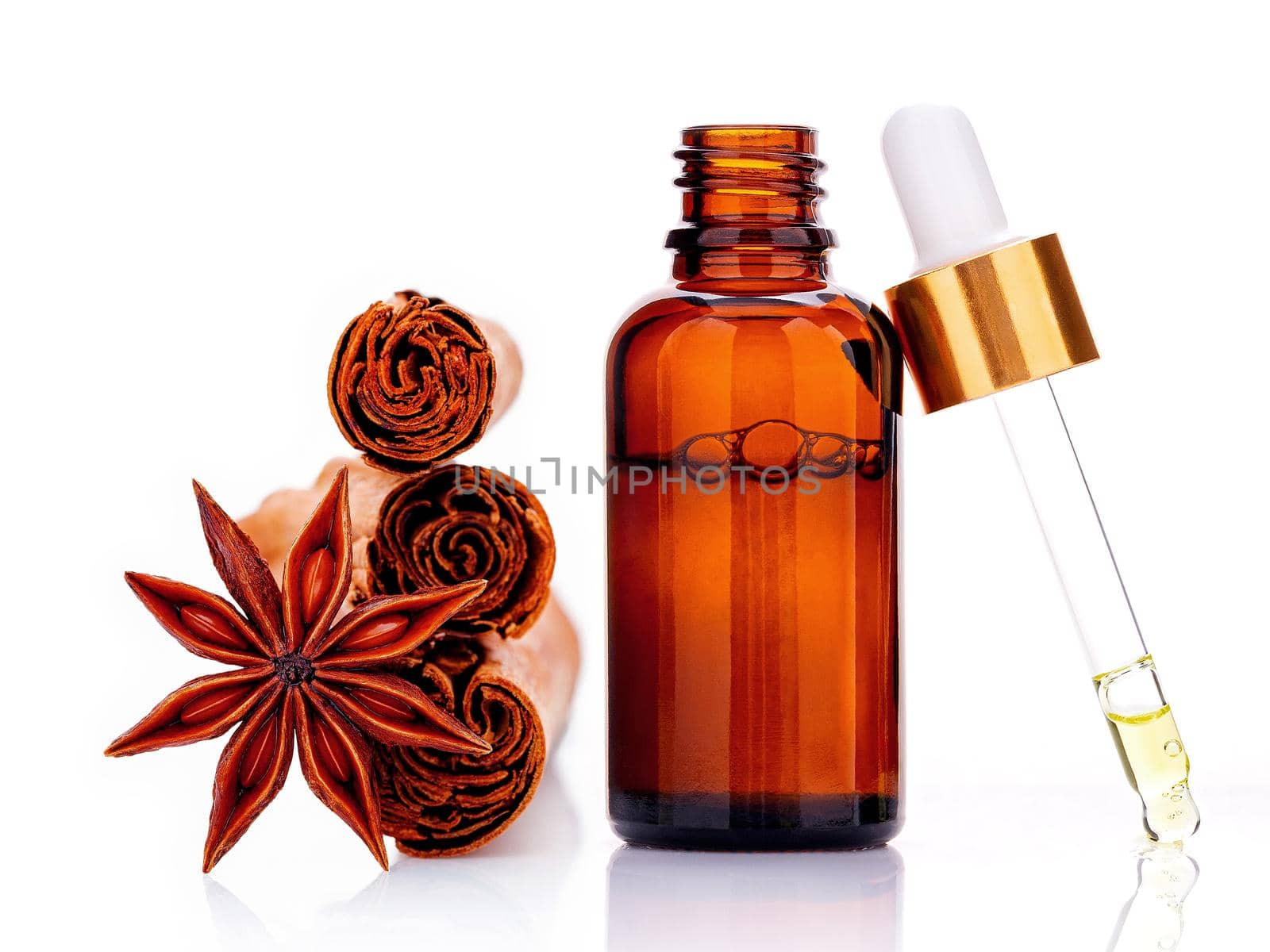 Cinnamon essential oil bottle with Ceylon cinnamon sticks and anise star isolated on white background . by kerdkanno