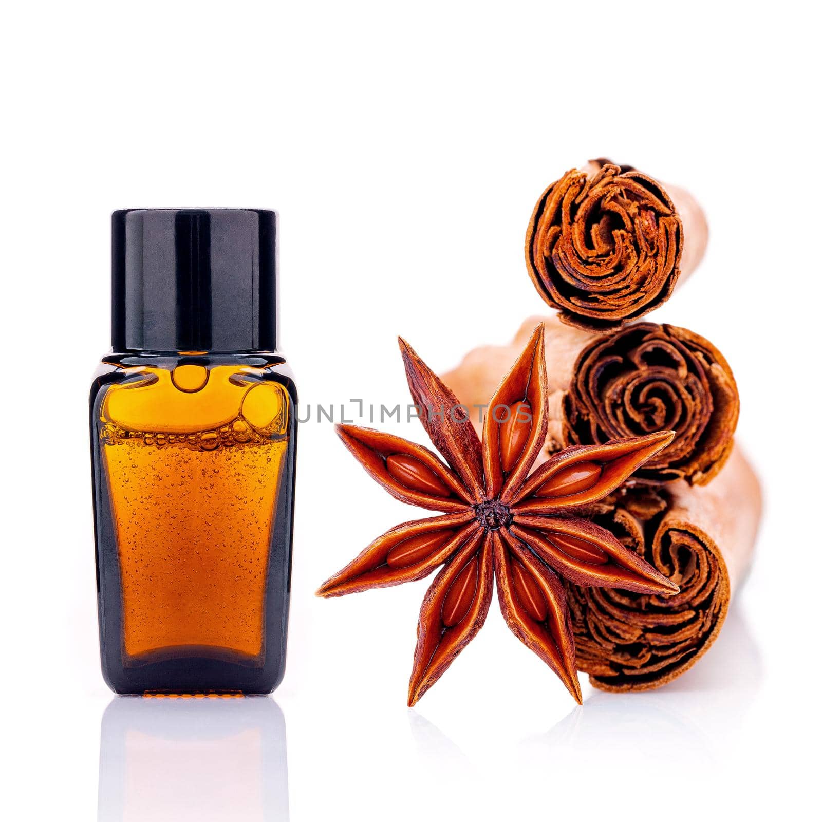 Cinnamon essential oil bottle with Ceylon cinnamon sticks and anise star isolated on white background . by kerdkanno