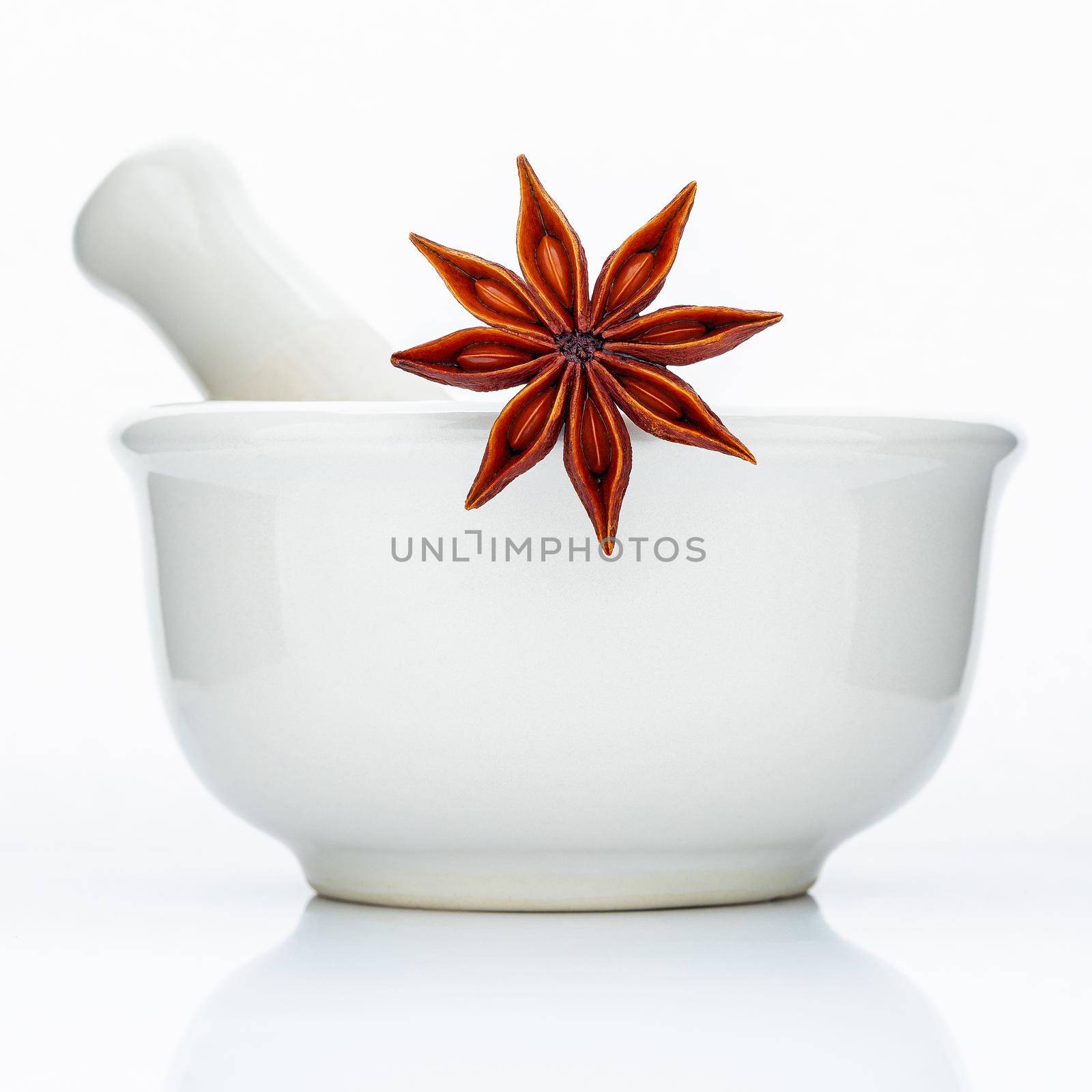 Closeup star anise in the white mortar isolated on white background . Food conceptual ingredients and medical.  by kerdkanno