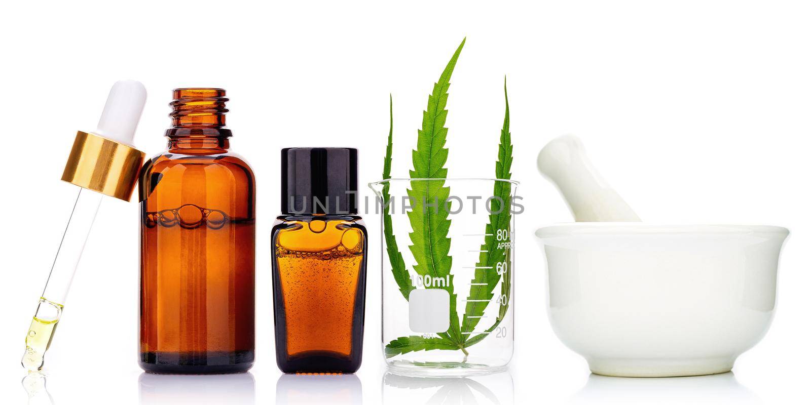 Glass bottles of cannabis oil and hemp leaves isolated on white background. Concept of using hemp in medicine. by kerdkanno