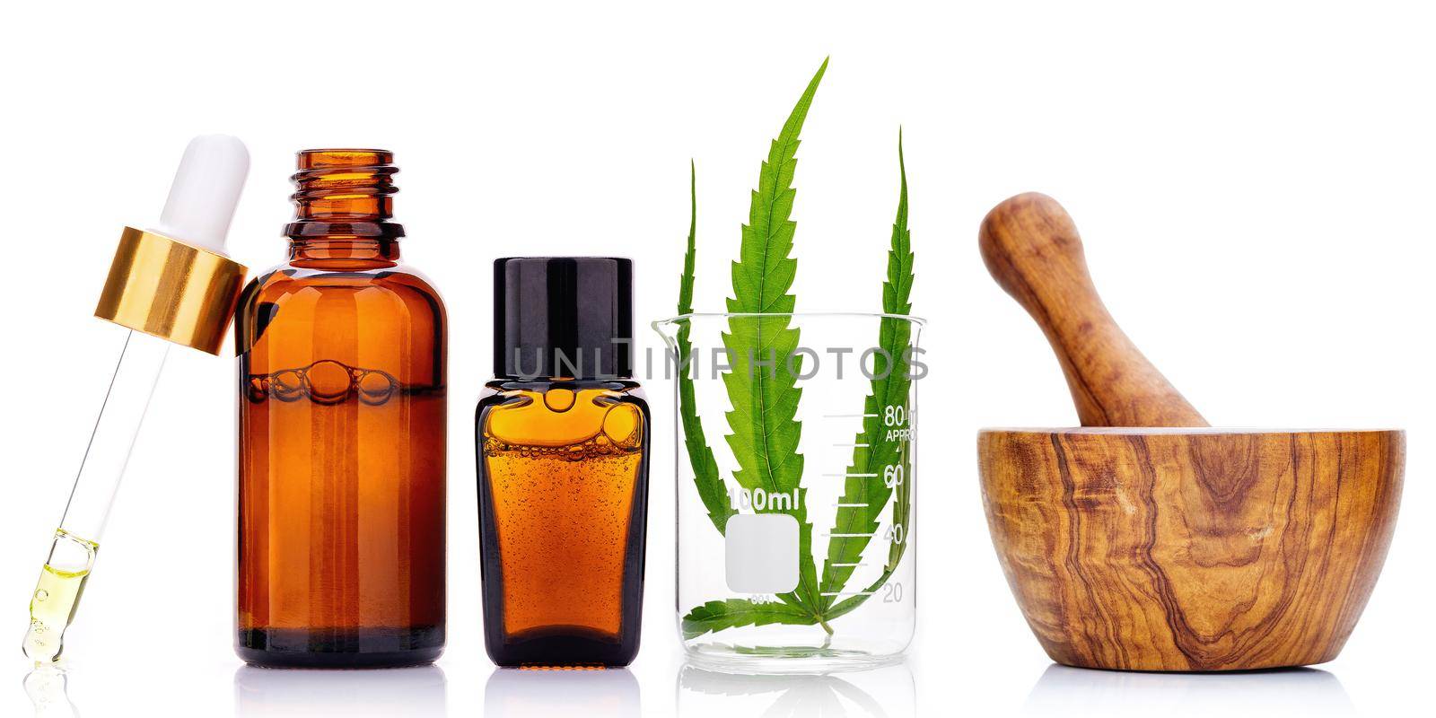 Glass bottles of cannabis oil and hemp leaves isolated on white background.

