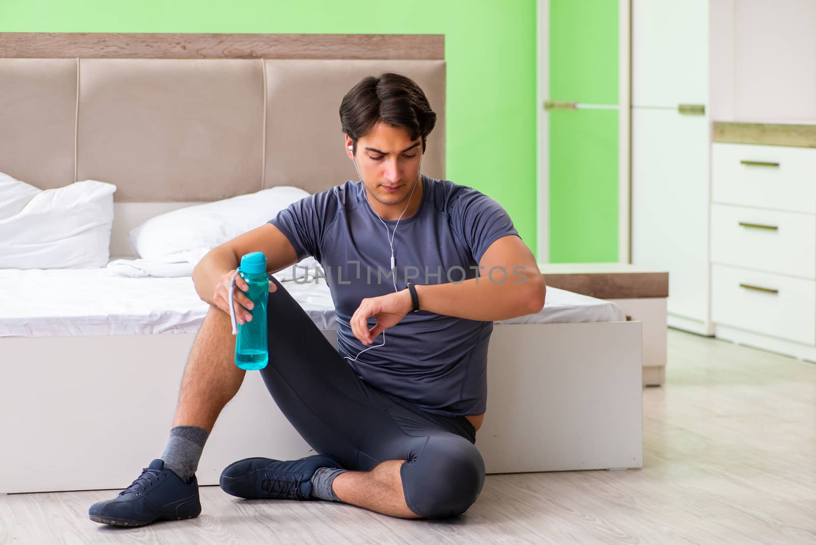 Young handsome man doing morning exercises in the hotel room