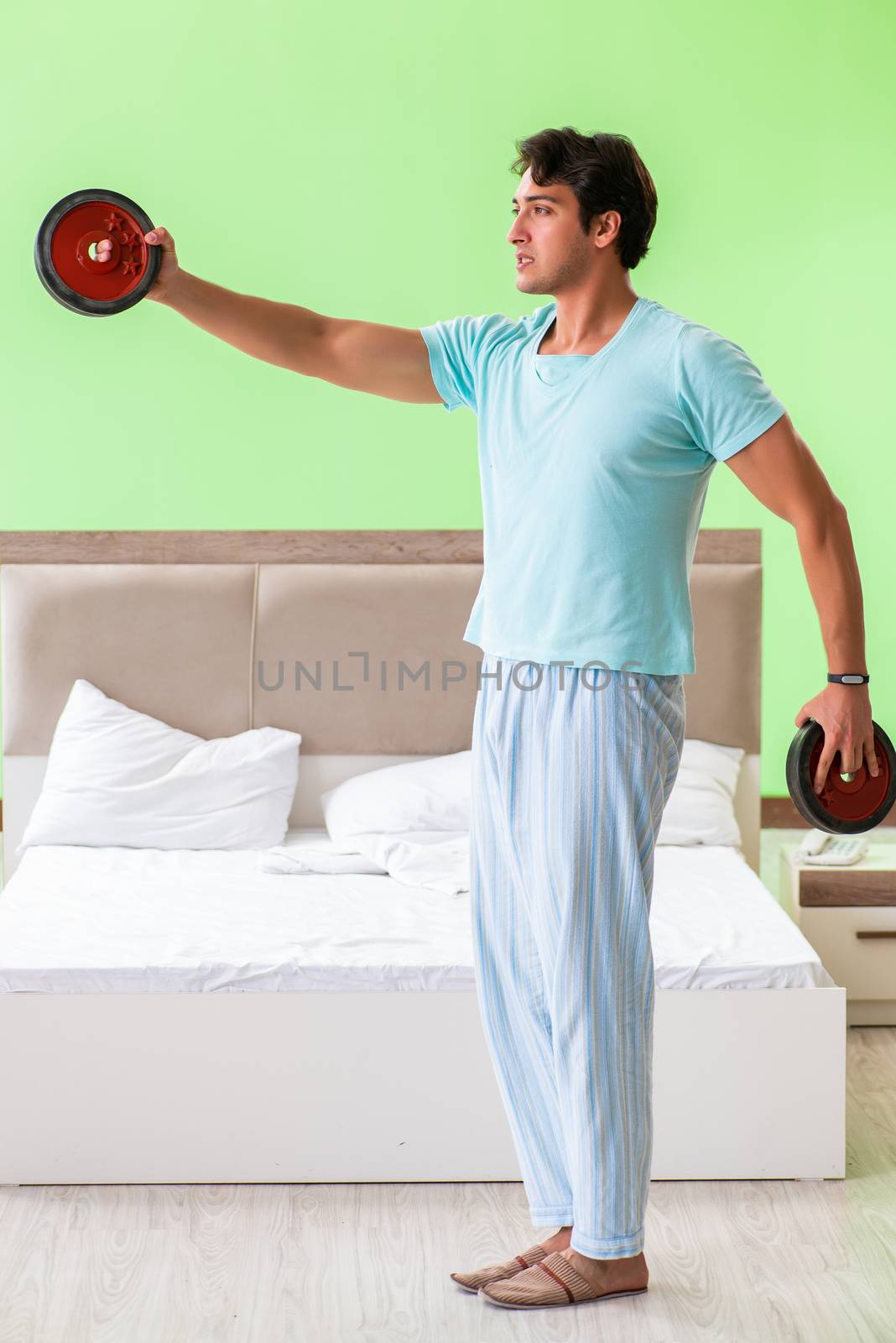 Young man in pajamas doing morning exercises 