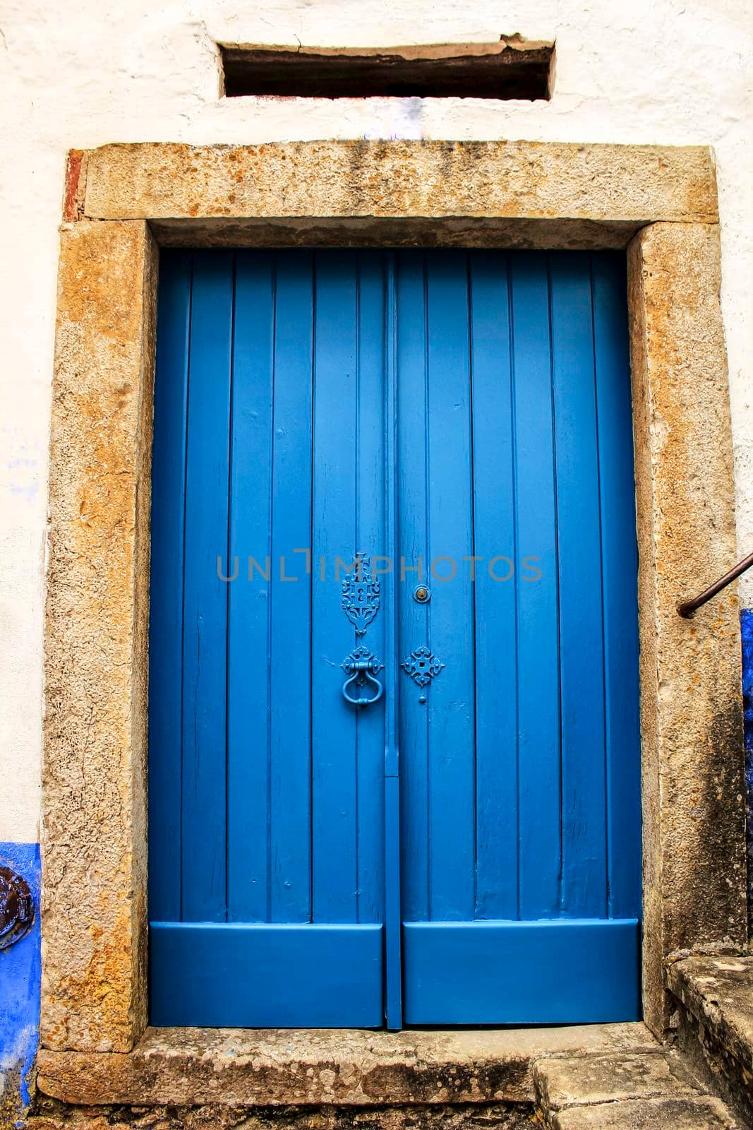 Old wooden door in Lisbon. Wrought metal details on the door.