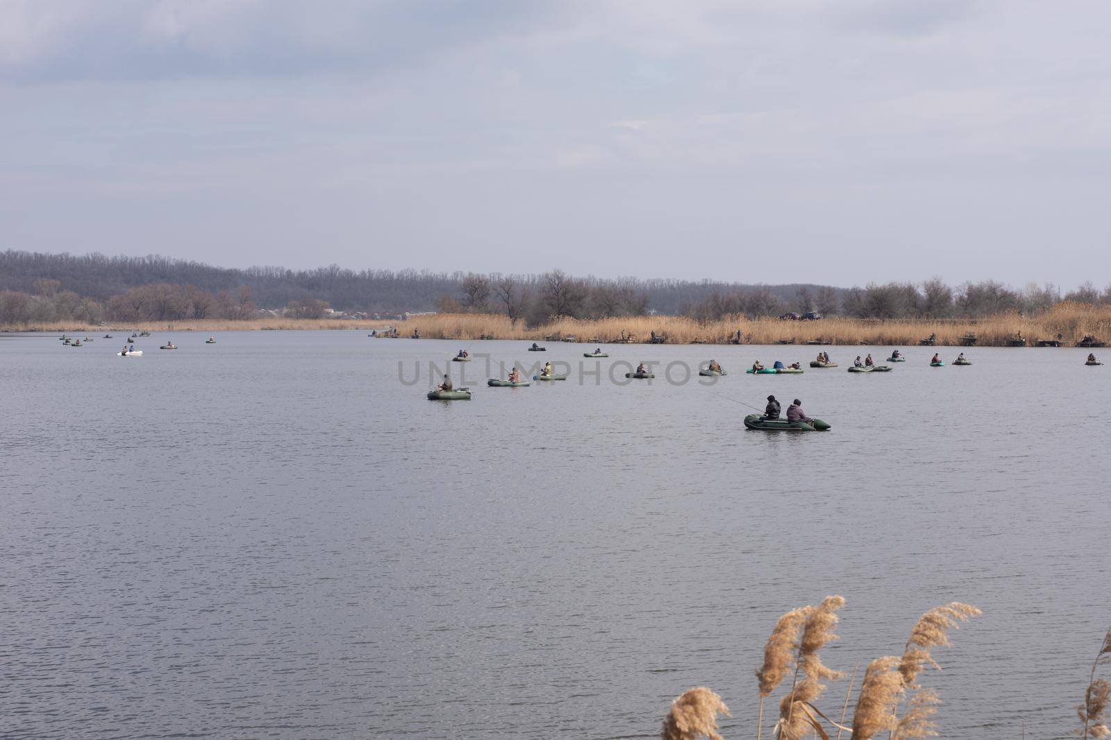 Spring fishing. Fishermen on boats catch fish with fishing rods.