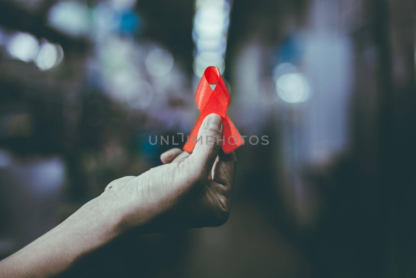 World AIDS day awareness ribbon,Female hands holding red ribbon HIV,Healthcare and medicine concept.