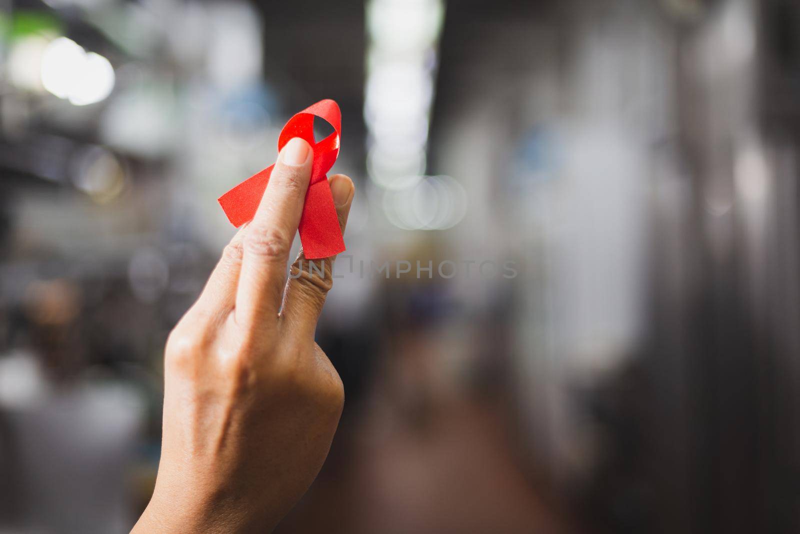 World AIDS day awareness ribbon,Female hands holding red ribbon HIV,Healthcare and medicine concept.