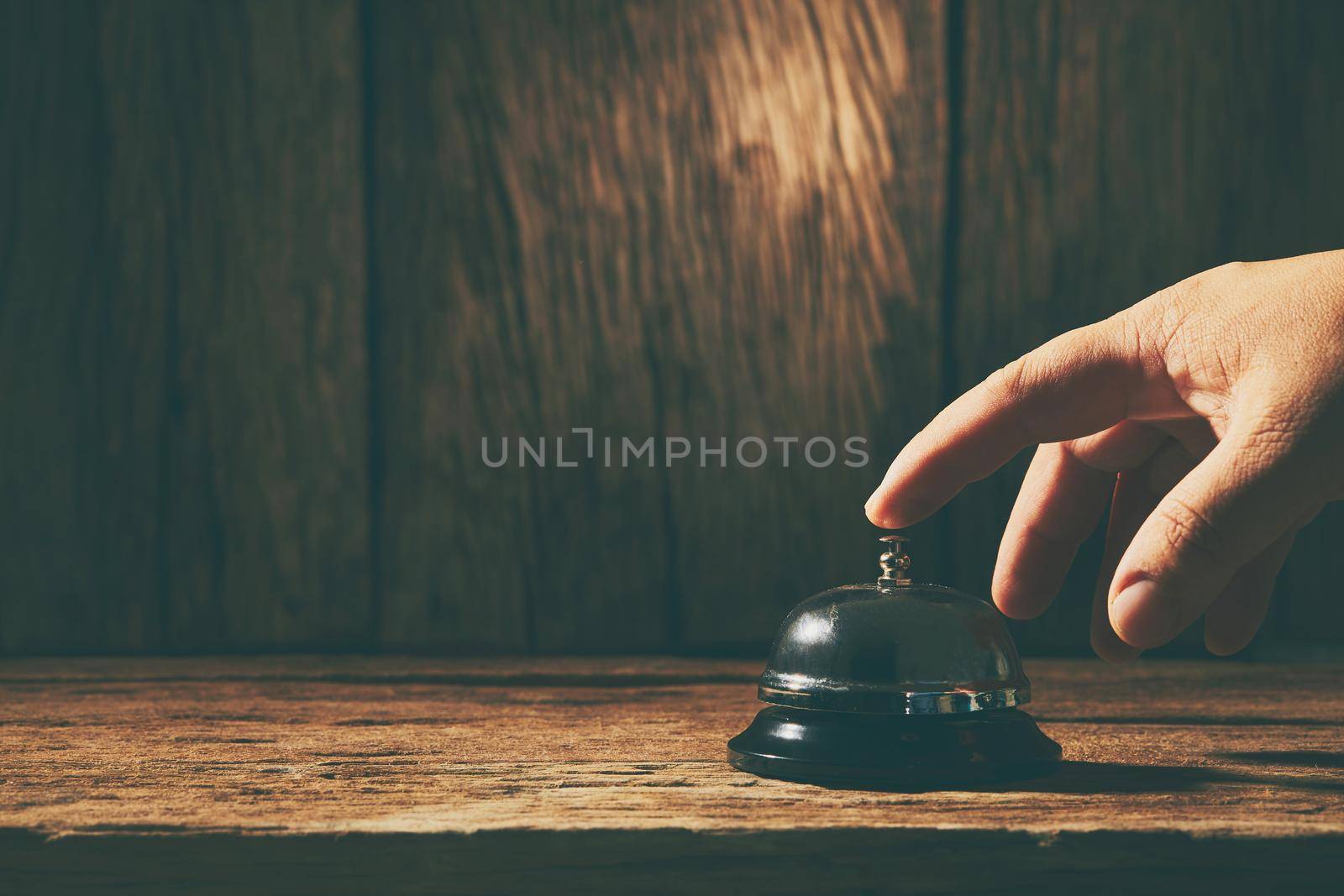 Bell service with hand on wood background