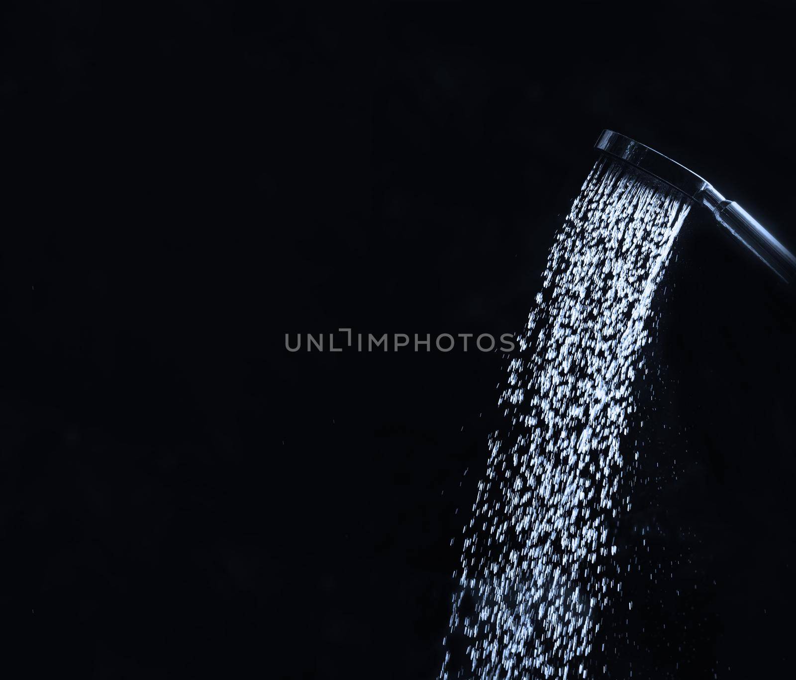 running water of shower faucet on dark background