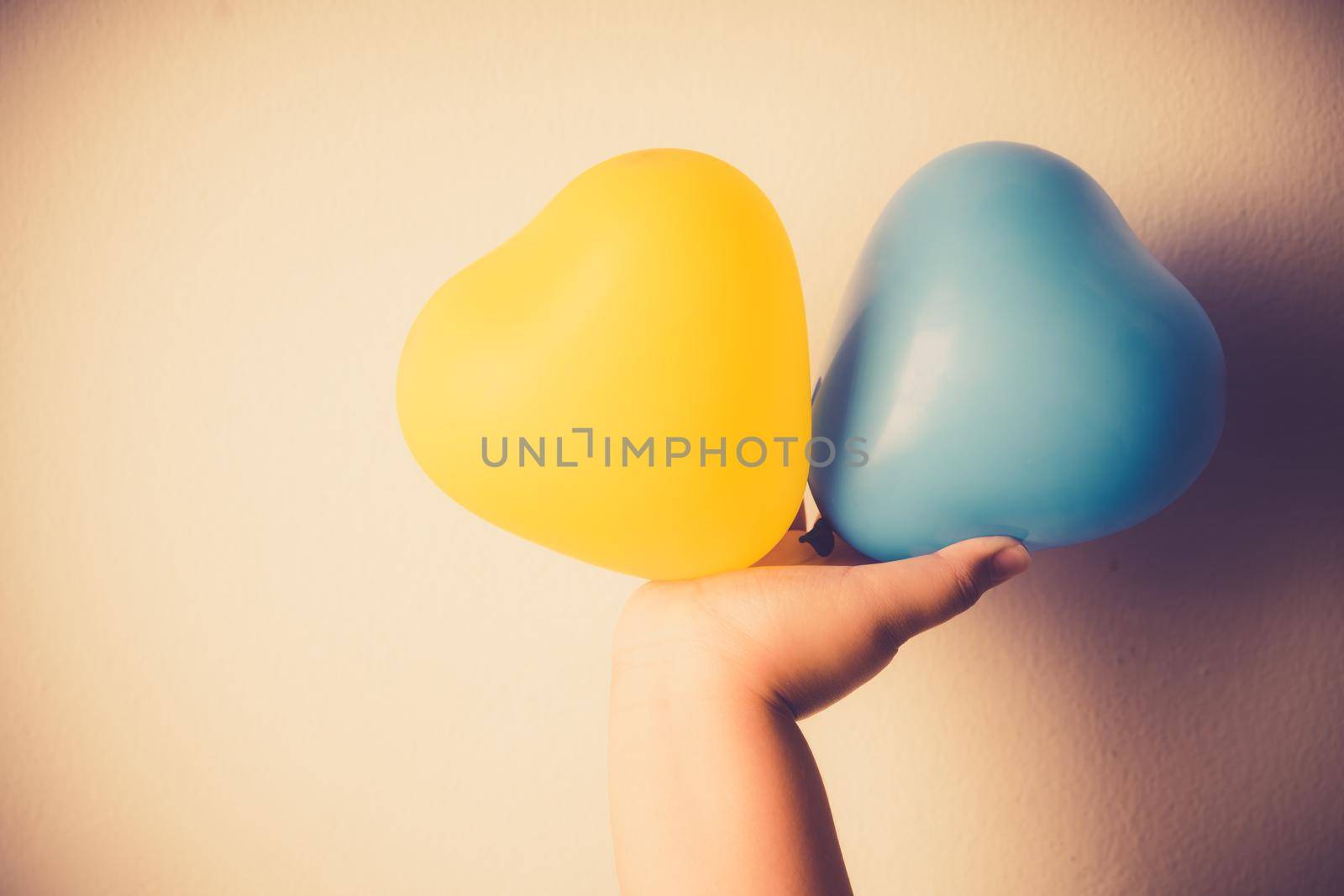 Heart-shaped balloons represent the sign of Down syndrome children. Balloons on hand