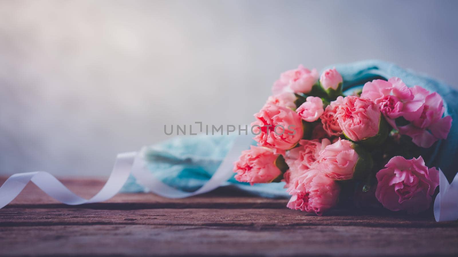 Still life with sweet carnation flowers on wooden table, Mothers day concept