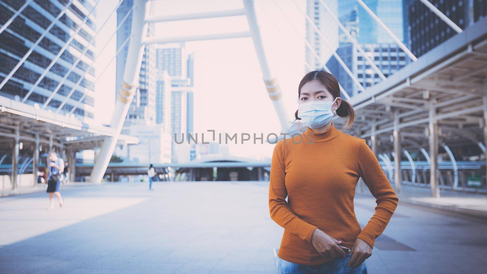 Young woman wearing protective face mask outdoors in city street. New Normal life after COVID-19 and health protocols to avoid infections and the virus spread in public spaces. Thailand