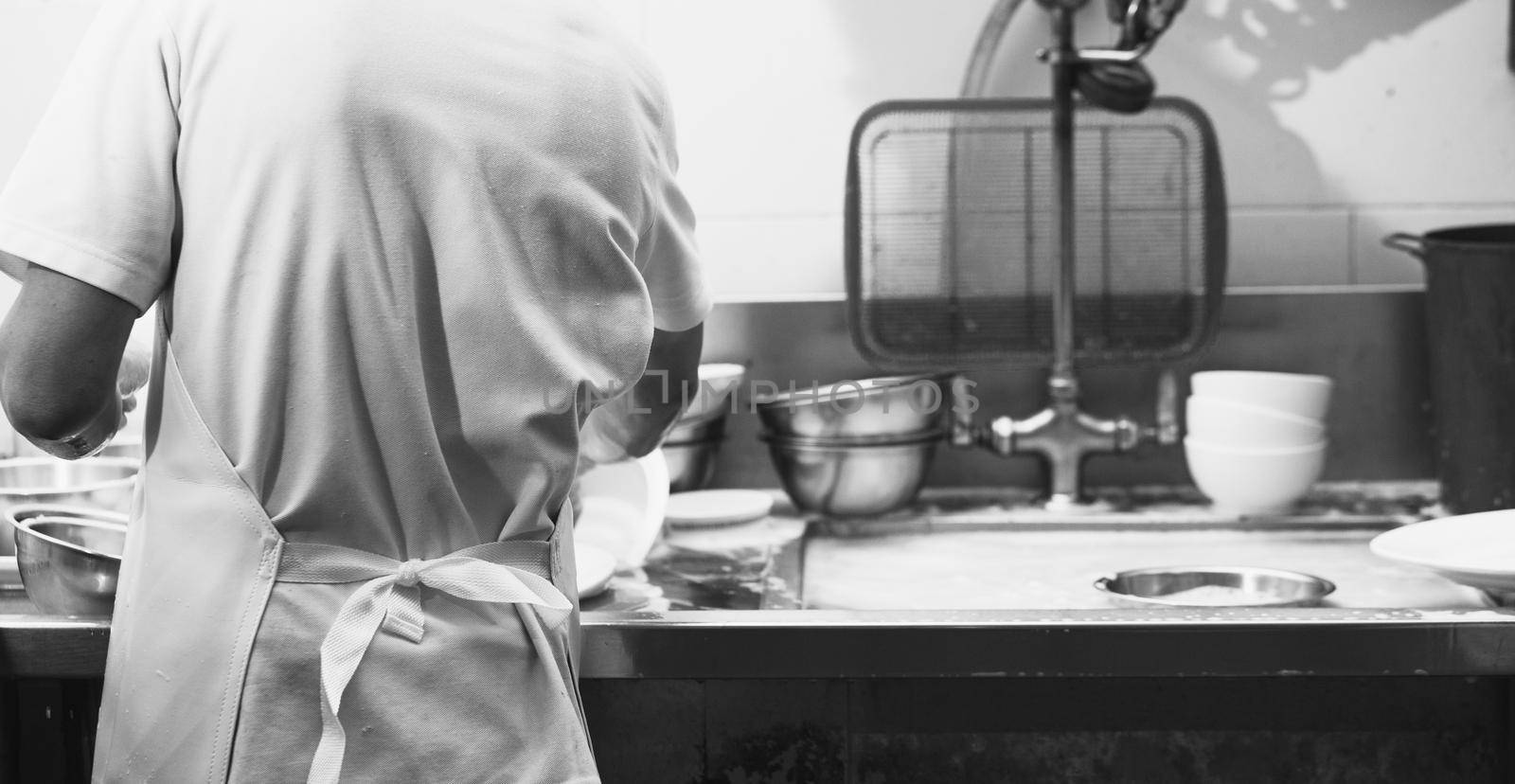 Man washing dish on sink at restaurant