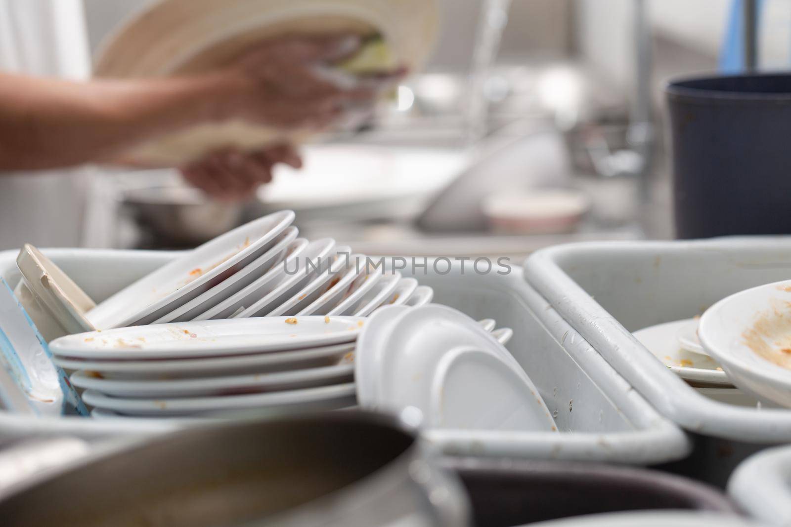 Man washing dish on sink at restaurant