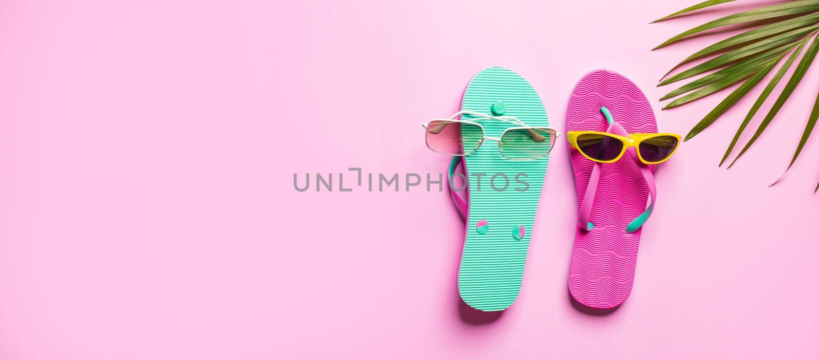 Summer background , Flip flop with palm branch  on pink background, space for text