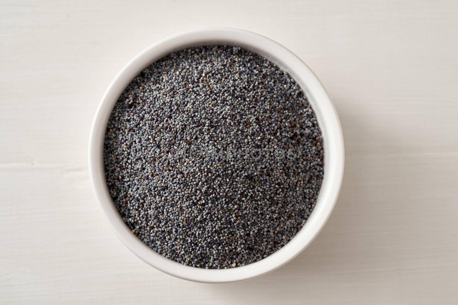 Poppy seeds in a bowl on a white background, top view by madeleine_steinbach