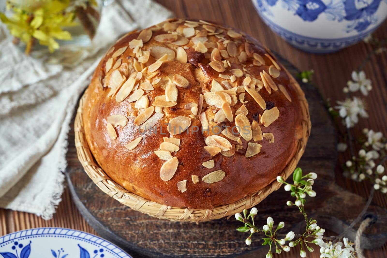 Whole mazanec, traditional Czech sweet Easter pastry, similar to hot cross bun, with blooming branches in spring