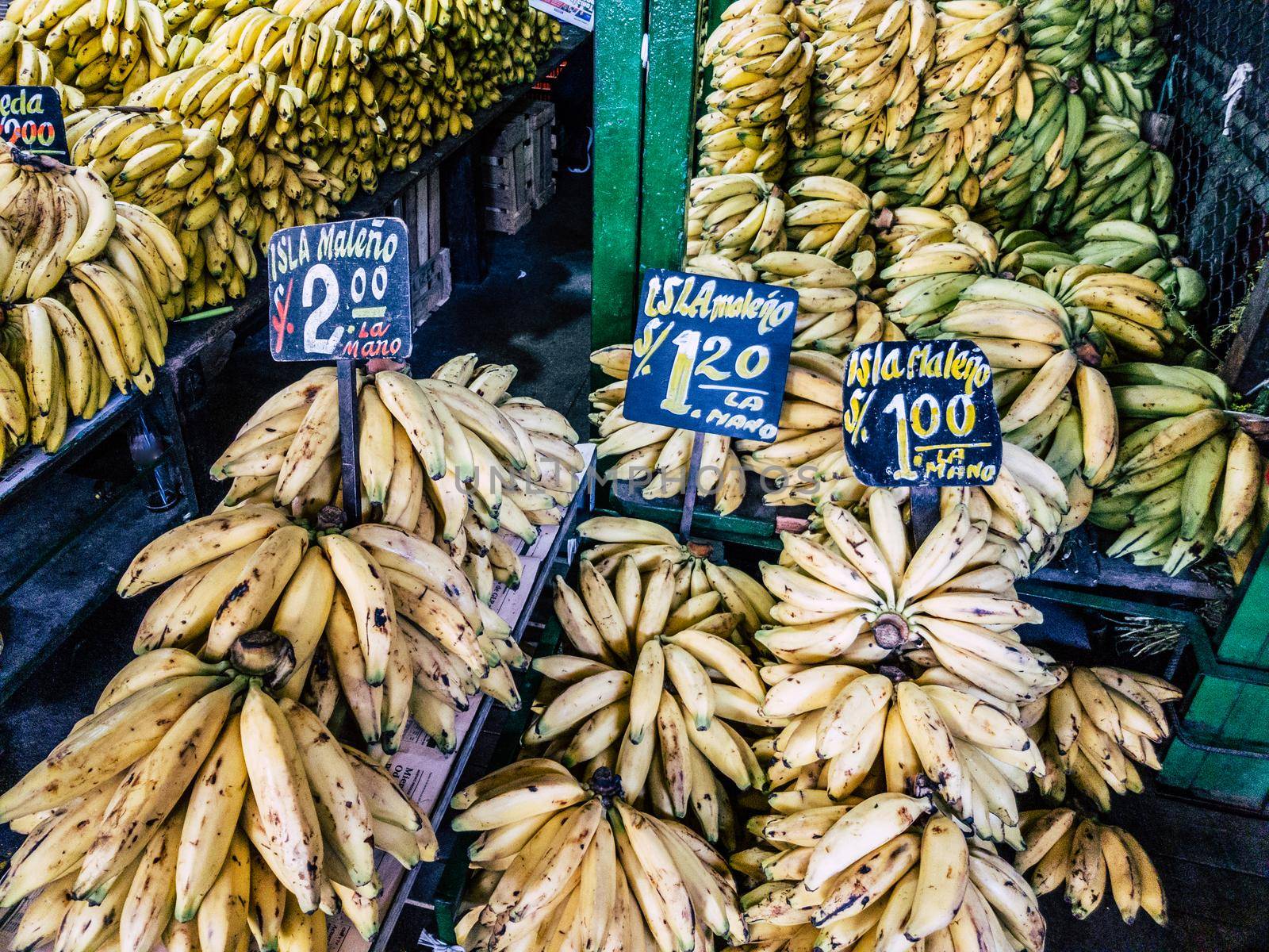 Sale of bananas in the market with signs that say the type of banana that is sold: island bananas