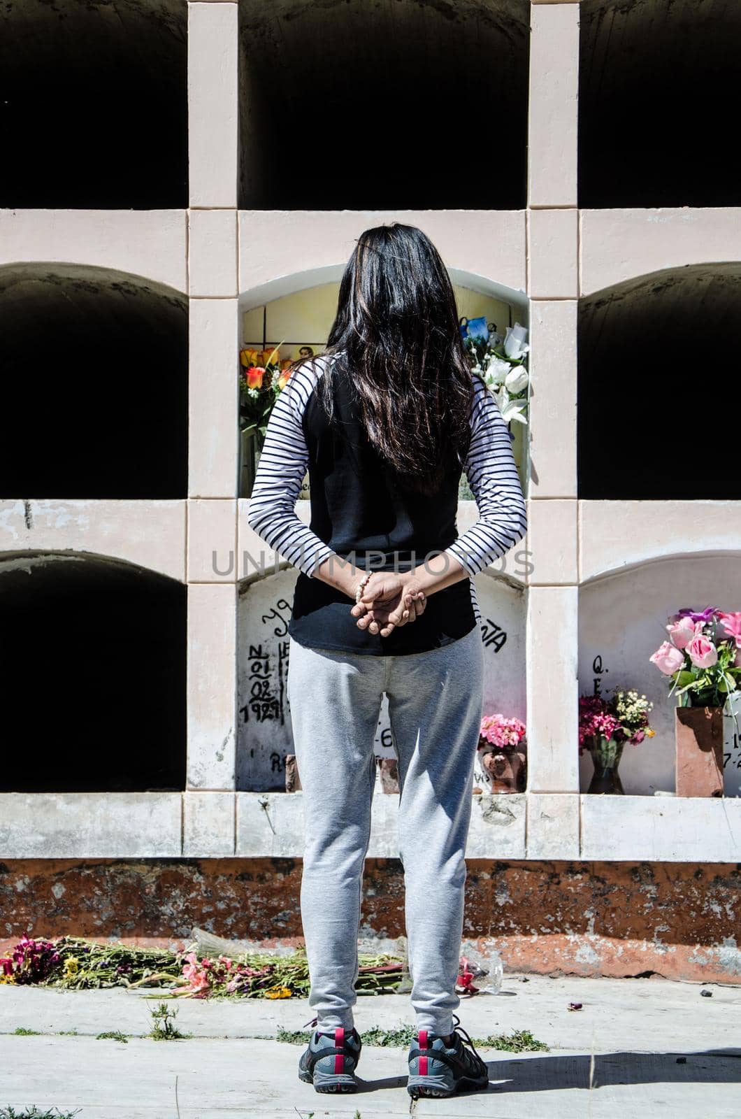 Close-up of a Sad Woman from behind contemplating the grave of a loved one