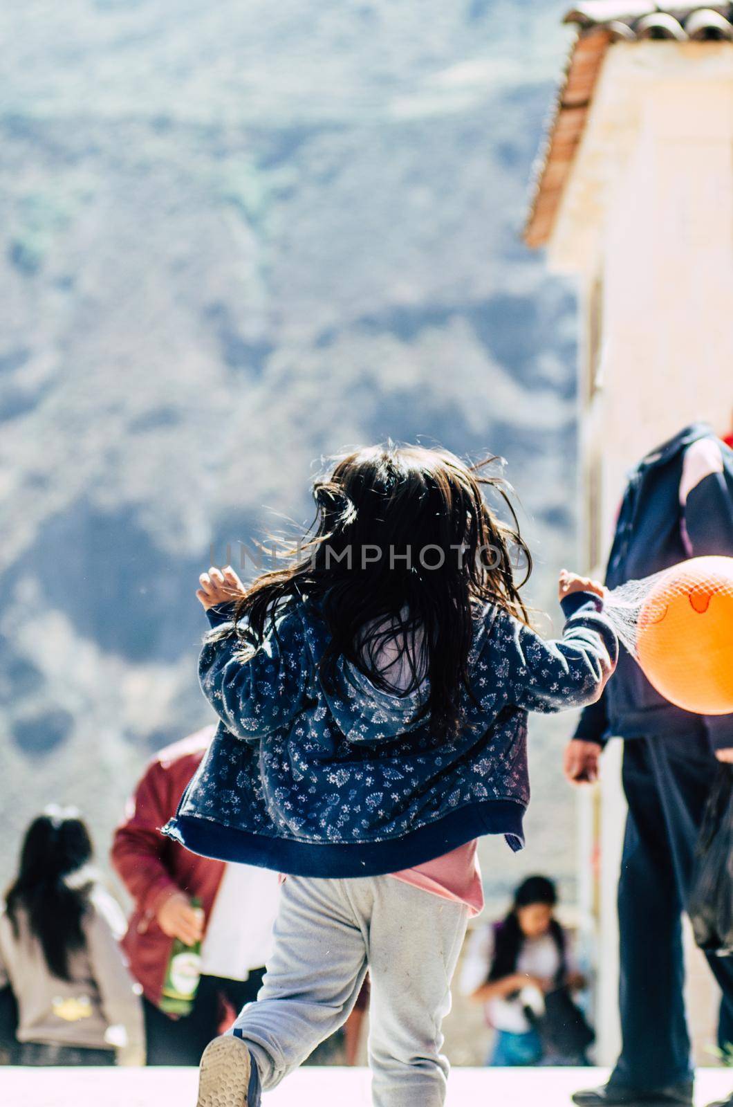 Little girl with a ball in her hands looking back