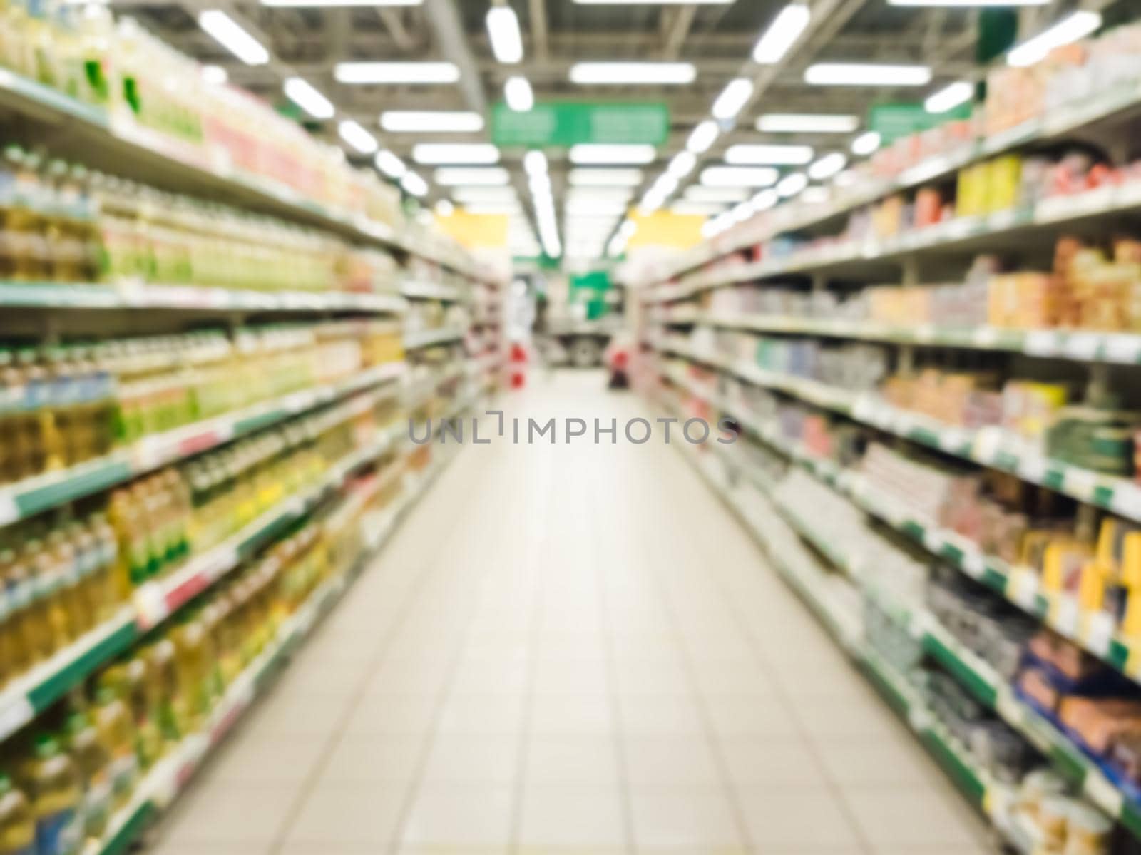 Blurred supermarket aisle with colorful shelves of merchandise. Perspective view of abstract supermarket aisle with copy space in center, can use as background or retail concept