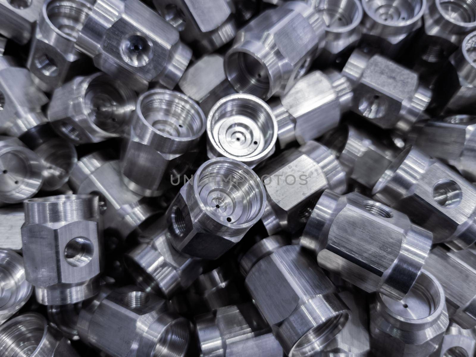 heap of abstract industrial close-up background of shiny steel turned hexagonal parts.