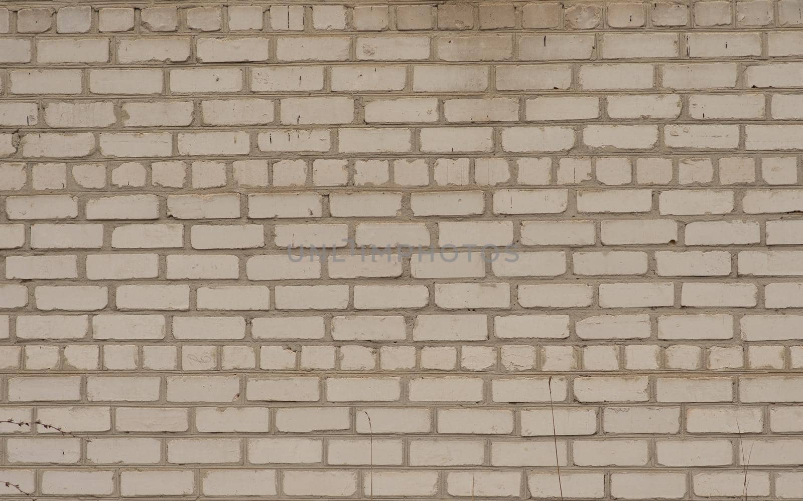 A white horizontal brick textured wall, yellowed with age. High quality photo