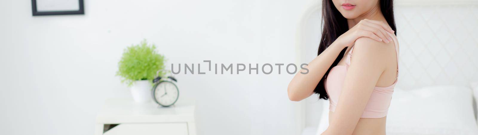Beautiful sexy young asian woman applying cream on shoulder and message, beauty girl applying body lotion skin care for health and soft hydration, treatment and cosmetic with moisturizer. by nnudoo