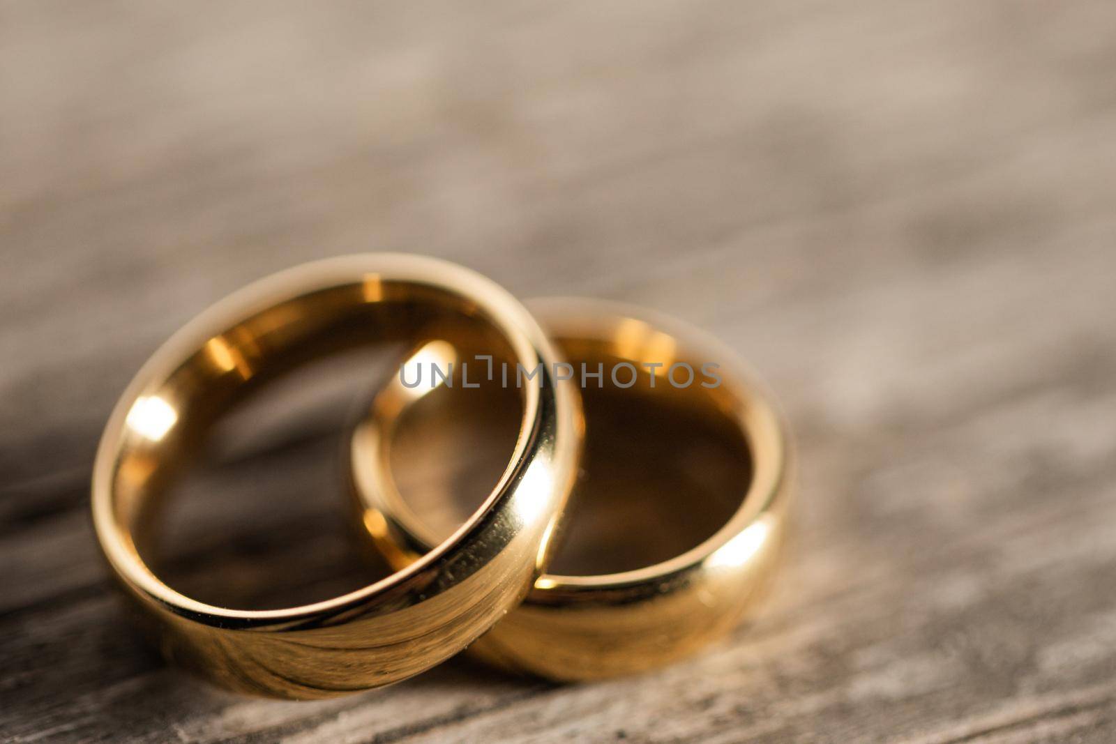 Two golden wedding rings on wooden background