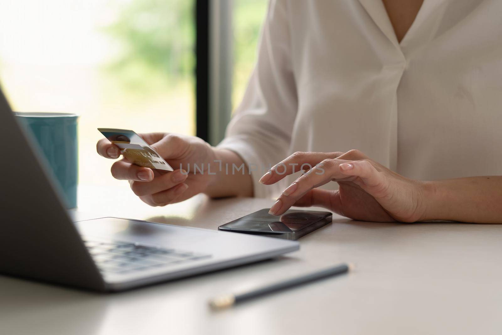 Close up of female hands making online payment for online shopping at home.