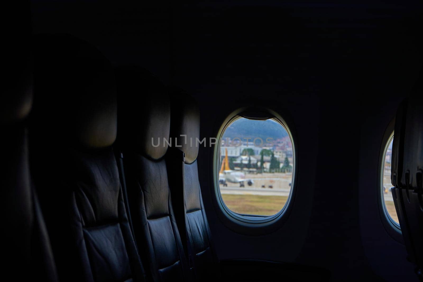 Dark airplane interior. Three free seats by the window. Airplane Before departure.