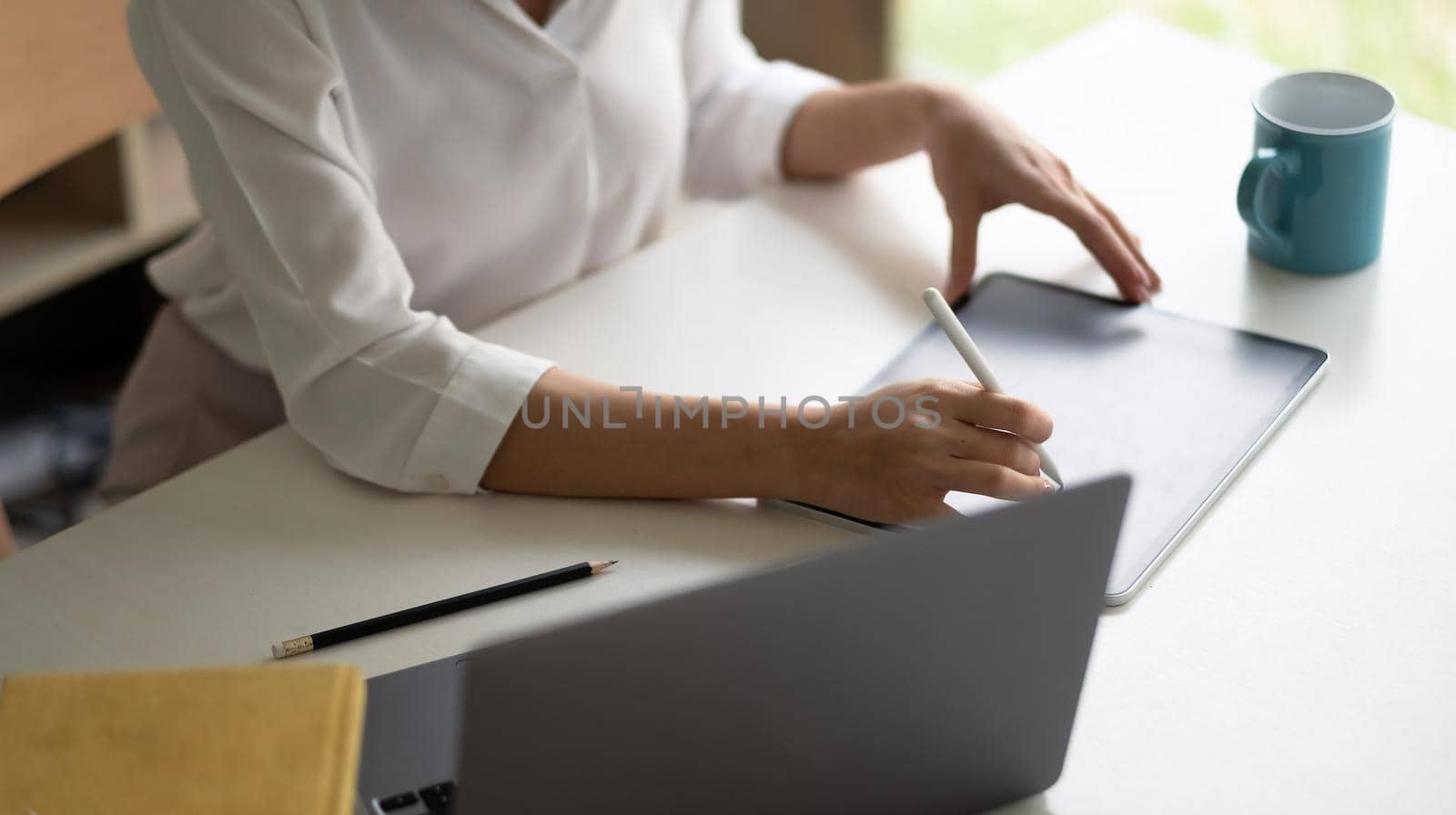 Close up business woman hand using stylus pen, work on digital tablet at workplace