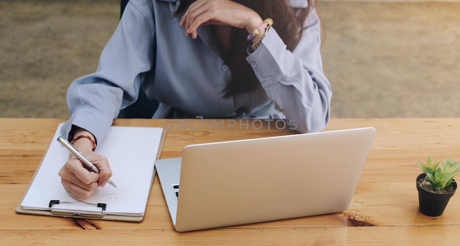 Businesswoman hand working with new modern computer and writing by wichayada