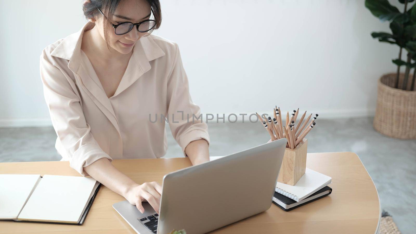 Focused woman journalist freelancer working online on laptop, sitting at desk at home, looking at screen, typing, serious young female writing blog or chatting with friends in social network

