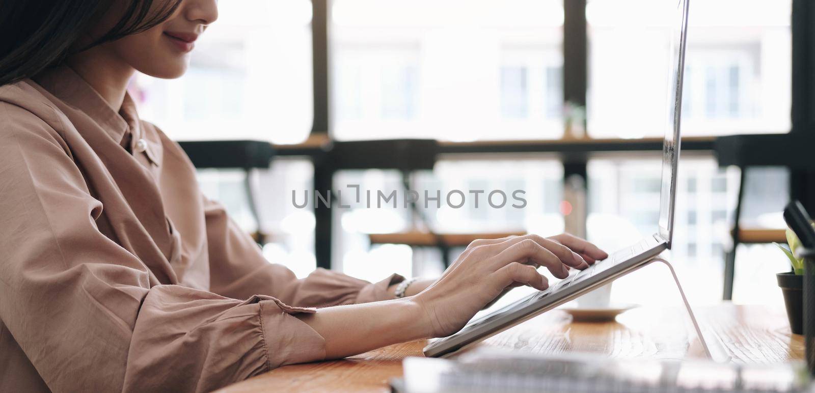 Focused woman journalist freelancer working online on laptop, sitting at desk at home, looking at screen, typing, serious young female writing blog or chatting with friends in social network
