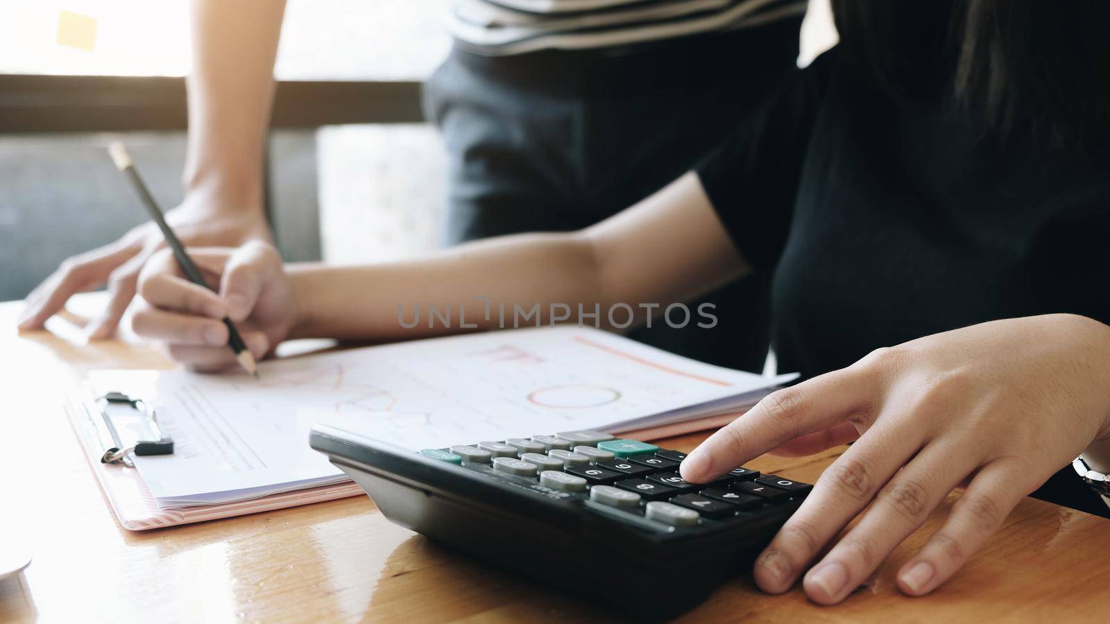 A male business consultant describes a marketing plan to set business strategies for women business owners with using calculator. business planning and researching concept.
