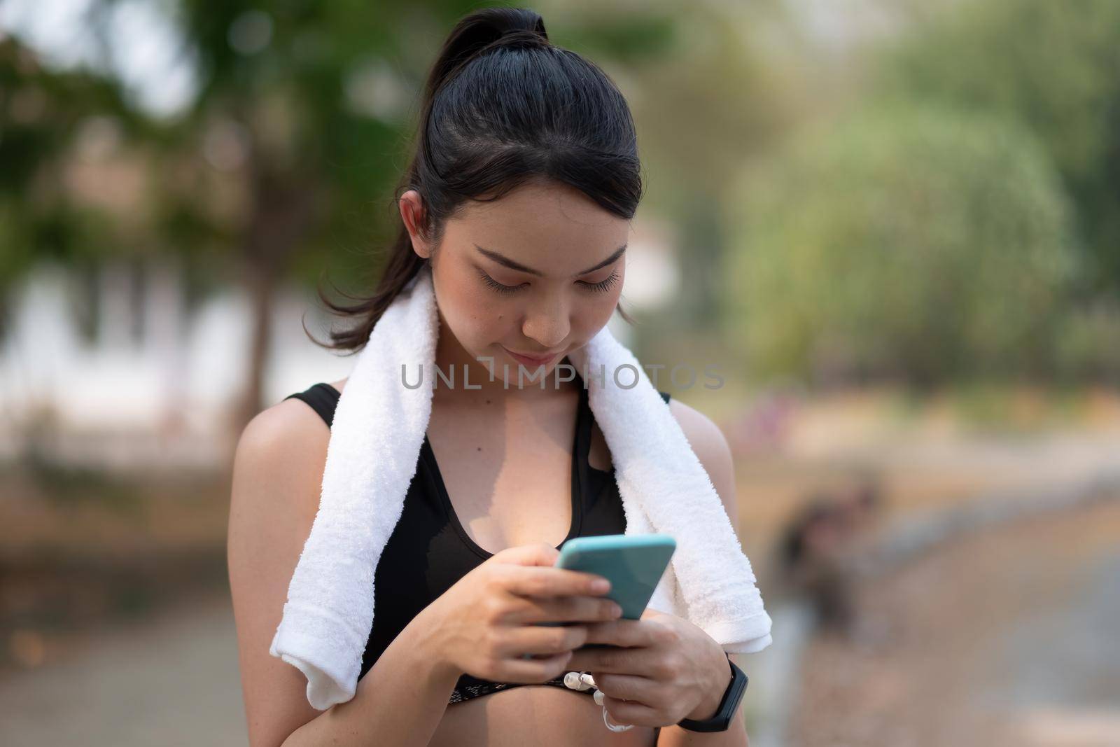 female athlete use smartphone waiting for training by nateemee