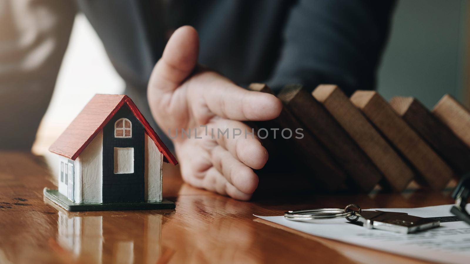 Protect the house from falling over the wooden blocks, Insurance and risk concept.
