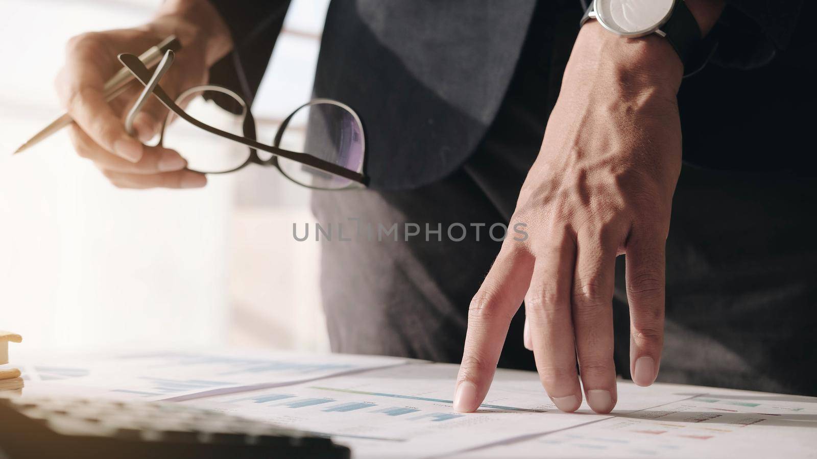 Close up of Businessman investment consultant analysis company annual financial report balance sheet statement working with documents graphs. Concept picture of economy, marketing by wichayada